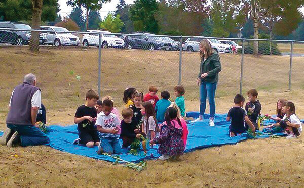 Mark Watrin, far left, teaches students from Glenwood Heights Primary School about gardening.