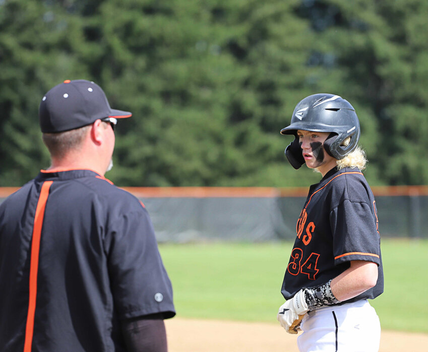 Napavine's Beckett Landram chats with a coach after getting on base against Forks in the 2B District 4 consolation quarterfinals May 9 in Napavine.
