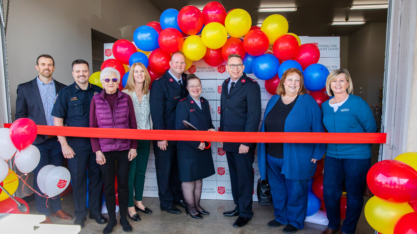 From left, Commissioner Sean Swope, Centralia Police Chief Stacy Denham, Mary Ellen Rafferty, Centralia Mayor Kelly Smith Johnston, Salvation Army Captains Steven and Gin Pack, Salvation Army Major Jonathan Harvey, Sharon Miracle, and Diane Raubuch smile for a photo during a ribbon-cutting ceremony for The Salvation Army food bank in Centralia.