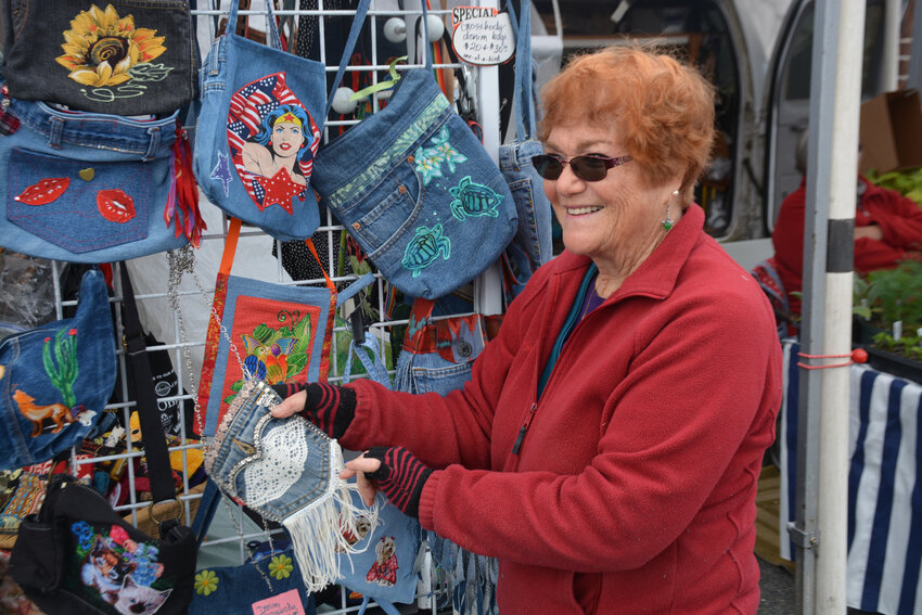 Carole Apple, a vendor at the Tenino Farmers Market, poses with several of her handmade purses.