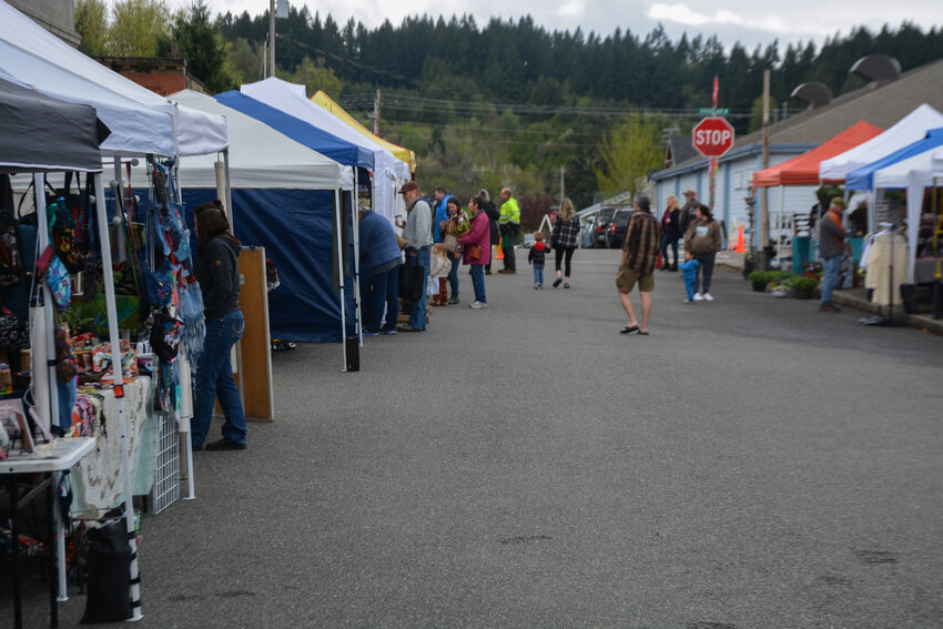 Customers walk throughout the Tenino Farmers Market and check out different vendors.