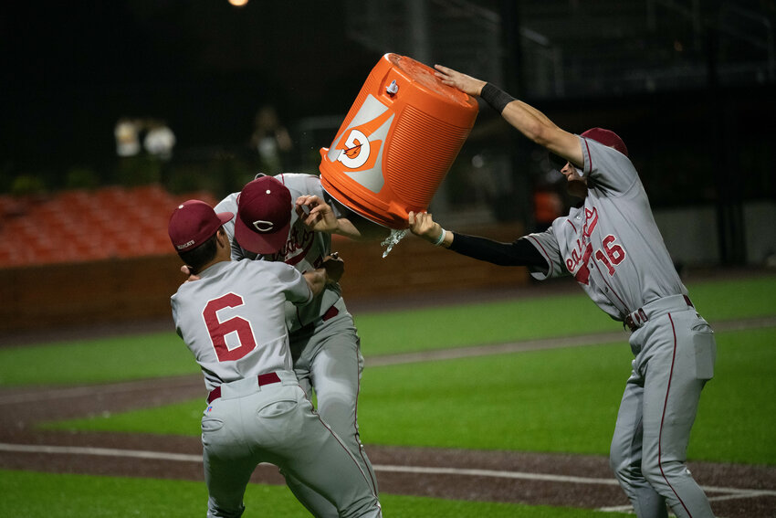 Deacon Meller tries to get Waylen Land with the water bath (having forgot that the Bearcats already emptied it on coach Jesse Elam) after W.F. West's 11-8 win over Tumwater in the district title game, May 12 in Ridgefield