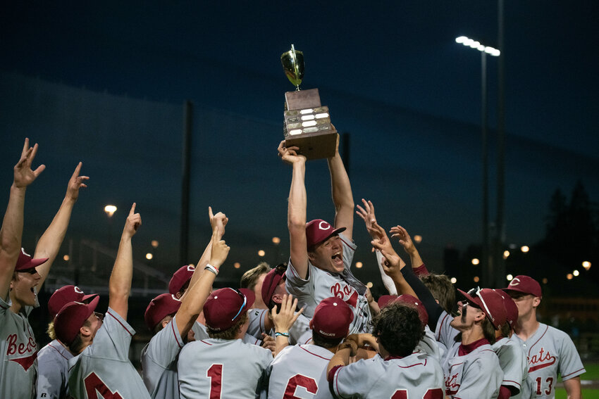 Waylen Land hoists the 2A District 4 trophy after W.F. West's 11-8 win over Tumwater in the district title game, May 12 in Ridgefield