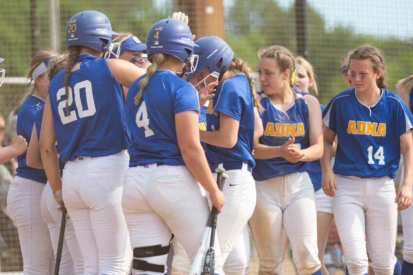 Adna's Brooklyn Loose is mobbed at the plate after a home run against Forks in the 2B District 4 semifinals at Borst Park in Centralia May 17.