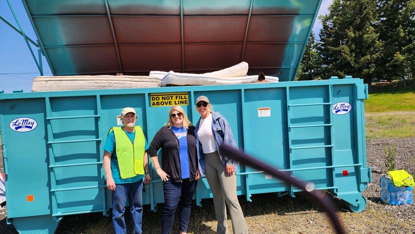 Chehalis Mayor Tony Ketchum, Experience Chehalis Executive Director Annalee Tobey and Visiting Nurses Foundation Executive Director Jacki Jewell are pictured in front of a full LeMay Inc. dumpster at the Chehalis Fire Station. Photo courtesy City of Chehalis.&nbsp;