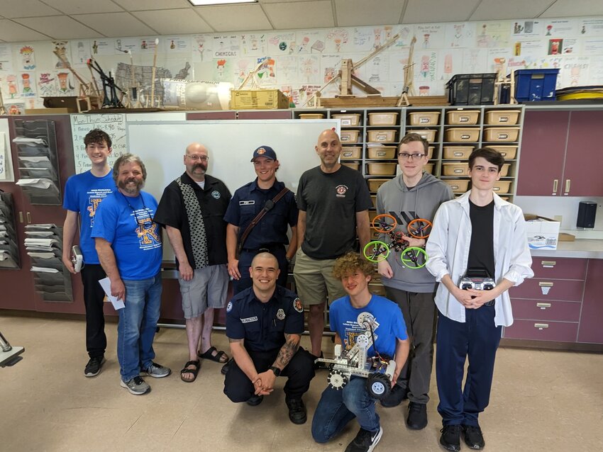 Members of the West Thurston Fire Authority union pose with members of the Rochester Robotics Team after donating $2,000 to the team.