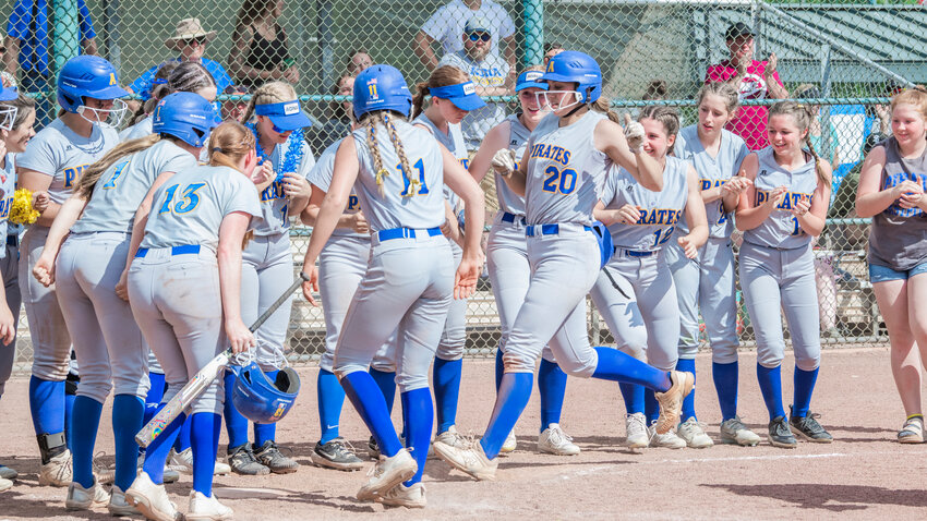 Adna's Karlee Von Moos (20) crosses home plate as teammates surround her to celebrate a grand slam during a game against Colfax at Kiwanis Park in Yakima on Friday, May 26.