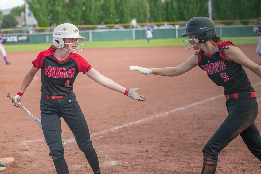 Abbie Lovan (left) high-fives Chesney Schultz (right) after both scored during the fourth inning of Mossyrock's 10-0 win over Quilcene in a loser-out game at the 1B state tournament, May 26 in Yaika.