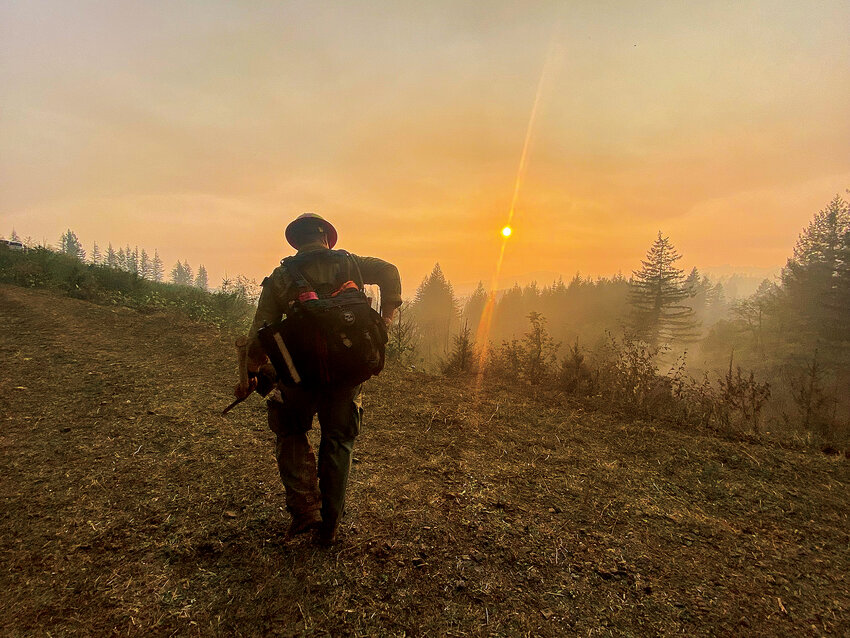 A firefighter walks near the Nakia Creek Fire zone near Larch Mountain.