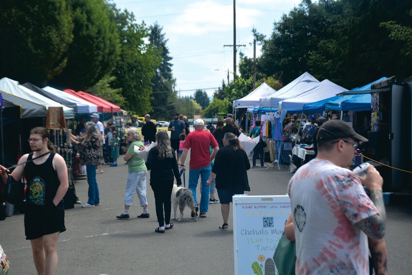 Customers walk throughout the Yelm Farmers Market on Saturday, May 27.