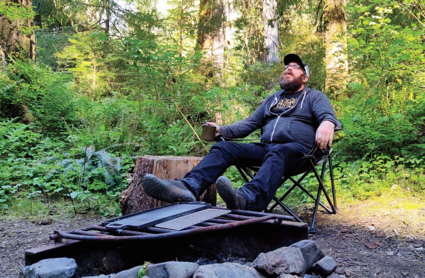 Aron Christensen is pictured seated at a campfire in this photo previously provided to The Chronicle by his family.