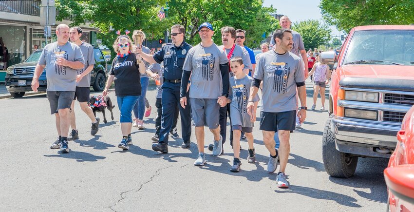 State Rep. Peter Abbarno holds the hand of his son Antonio Abbarno during the Lewis County Special Olympics Law Enforcement Torch Run in this Chronicle file photo.