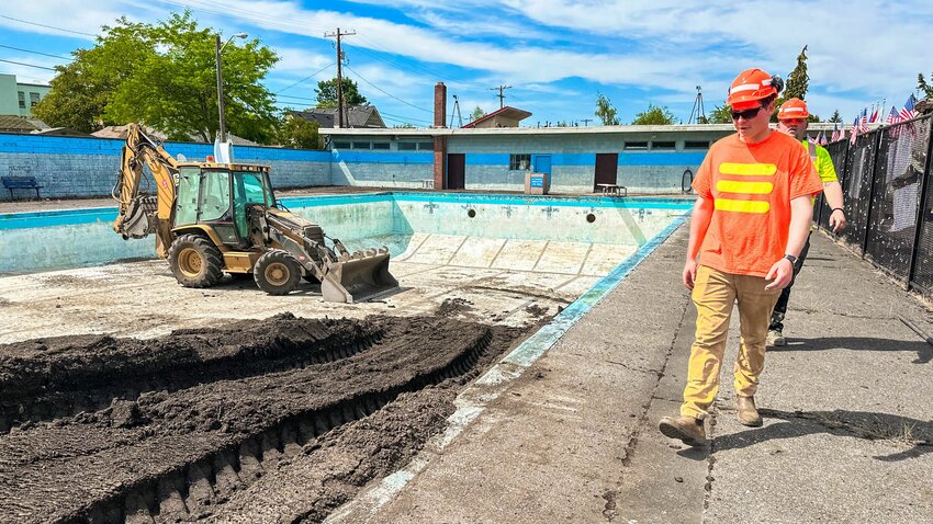 Workers begin filling in the Pearl Street Pool with dirt last week in Centralia.