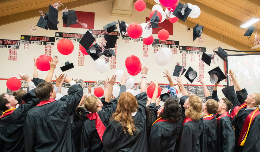 The Mossyrock High School class of 2023 throw graduation caps as they are showered in balloons at the end of a ceremony on Saturday, June 10.