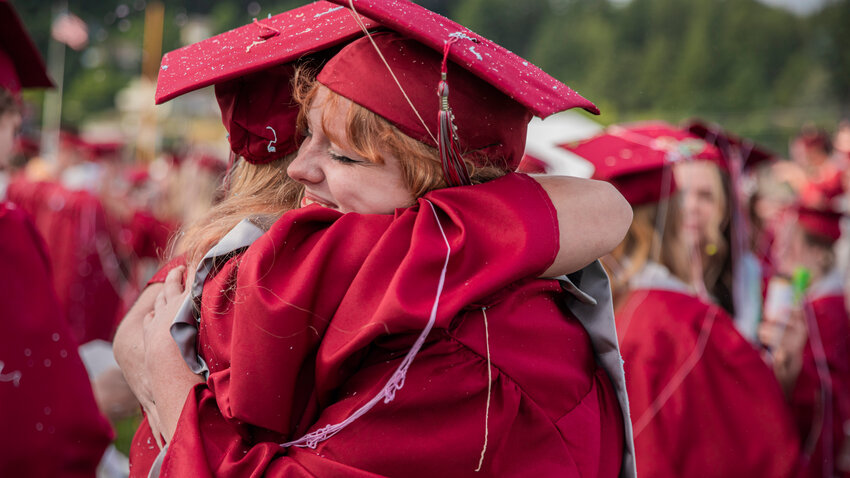 W.F. West graduates embrace after turning their tassels at Bearcat Stadium in Chehalis on Saturday, June 10.