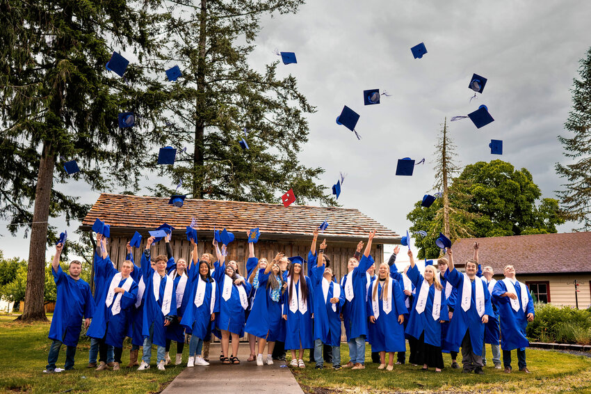 Cowlitz Academy graduates toss their caps as they are honored during a ceremony at St. Mary&rsquo;s in Toledo.