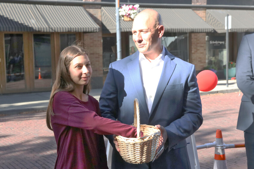 Rep. Peter Abbarno and his daughter, Sophia, choose a raffle winner by picking a business card out of a basket outside Althauser Rayan Abbarno LLC in Centralia on Thursday, June 15 during the Centralia-Chehalis Chamber of Commerce&rsquo;s Business After Hours event.