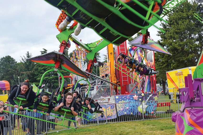 Attendees whip along a hang glider-oriented amusement ride at Woodland Planters Days on Saturday, June 17.