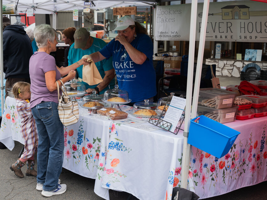 Pam Pierson and her great-granddaughter Nora Heldreth admire baked goods at the River House Bake Shop at the Chehalis Farmers Market in downtown Chehalis on Tuesday, June 20. The farmers market, which opened for the season earlier this month, is open from 11 a.m. to 4 p.m. each Tuesday on Boistfort Street in downtown Chehalis.  Vendors include Alucinor Farms, Black Dog Pottery, Boistfort Valley Farm, Good Earth Farm, Jam Nights, Piece by Piece Farm, Shadow&rsquo;s Farm, Sundial Gardens and Three Brothers Foods. Learn more by visiting https://chehalisfarmersmarket.com/.