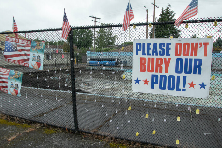 Signs, flags and tags with children's names written on them decorate the fence of the now permanently closed Pearl Street Pool, which the City of Centralia has begun to fill in as it prepares to create something else with the property.