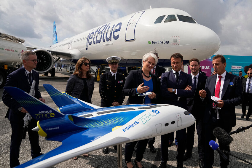 French President Emmanuel Macron, middle, and Airbus CEO Guillaume Faury, right, look at the concept hybrid-hydrogen aircraft Airbus Zero during the International Paris Air Show at the ParisLe Bourget Airport on June 19, 2023. (Michel Euler/Pool/AFP/Getty Images/TNS)