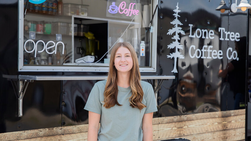 Saige Brindle smiles for a photo outside of the Lone Tree Coffee Co. mobile espresso trailer in Ethel on Monday, June 26.