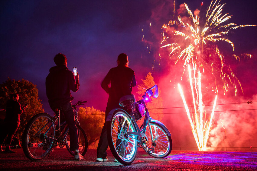 Fireworks explode in Packwood in July 2022 as onlookers take in the scene of Independence Day revelry.