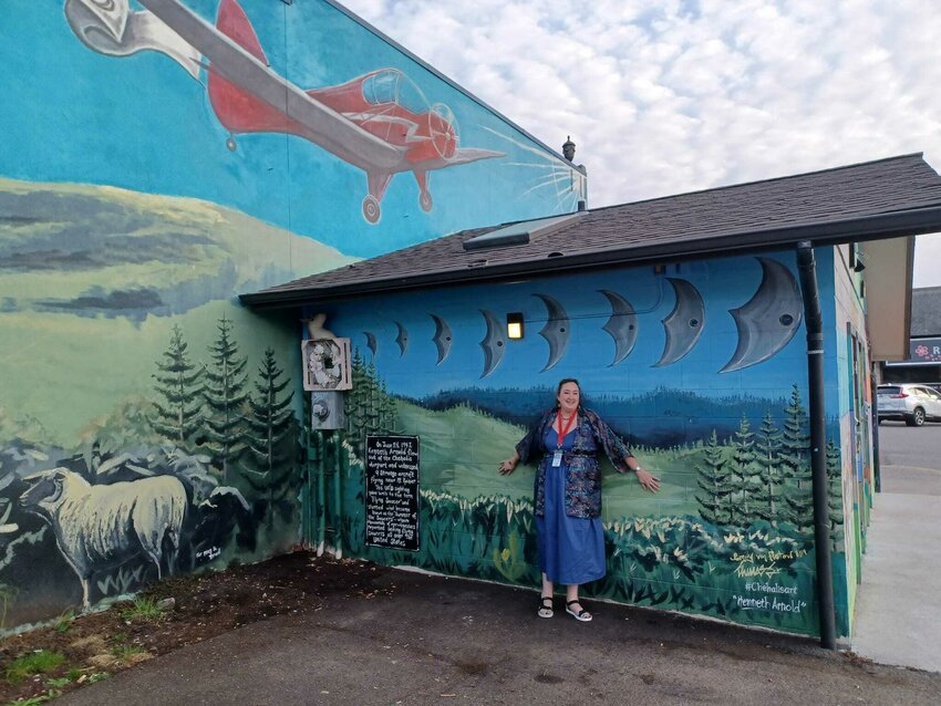 Schanelle Schanz poses in front of a mural in downtown Chehalis commemorating her grandfather Kenneth Arnold's famous 1947 UFO sighting in a photo provided by the Chehalis Flying Saucer Party. She will be returning this September as a speaker at the party sharing her grandfather's story.