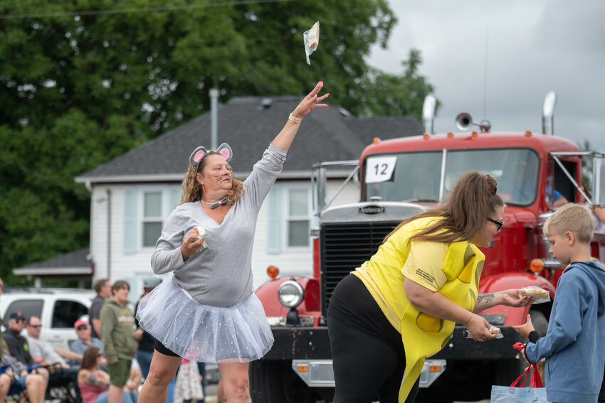 Participants distribute cheese sandwiches to the crowd at the the Toledo Cheese Days Parade on July 8.