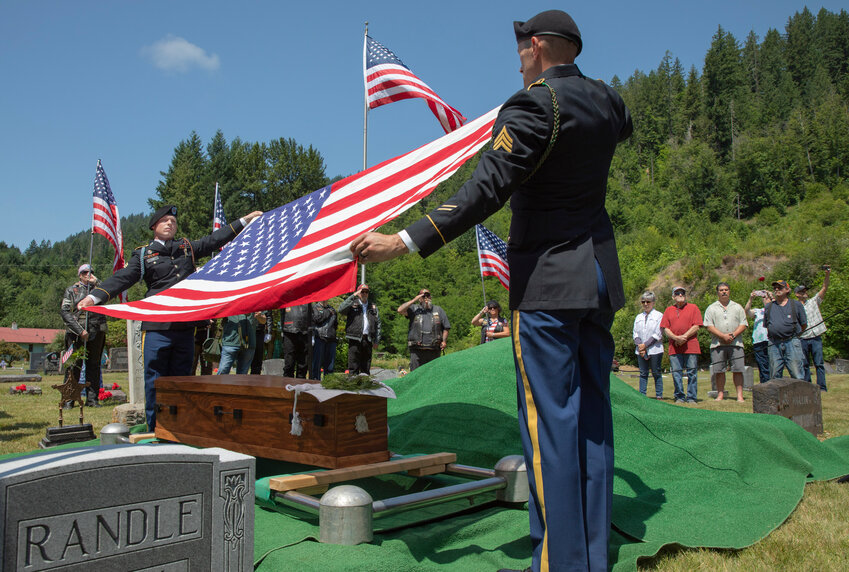 An American flag is hoisted off the casket of James Randles, a Civil War Veteran, before being displayed, folded and given to his family during a reburial ceremony in his namesake town on Saturday, July 8.