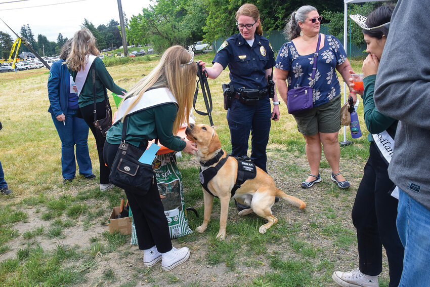 Woodland Police Wellness Dog Bolo, along with his handler, Lt. Jen Ortiz, greet the Woodland Planters Days court following a groundbreaking for the new Woodland Community Library on June 17.