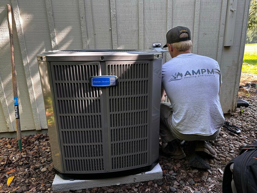 AMPM Heating and Cooling is seen servicing an HVAC unit.