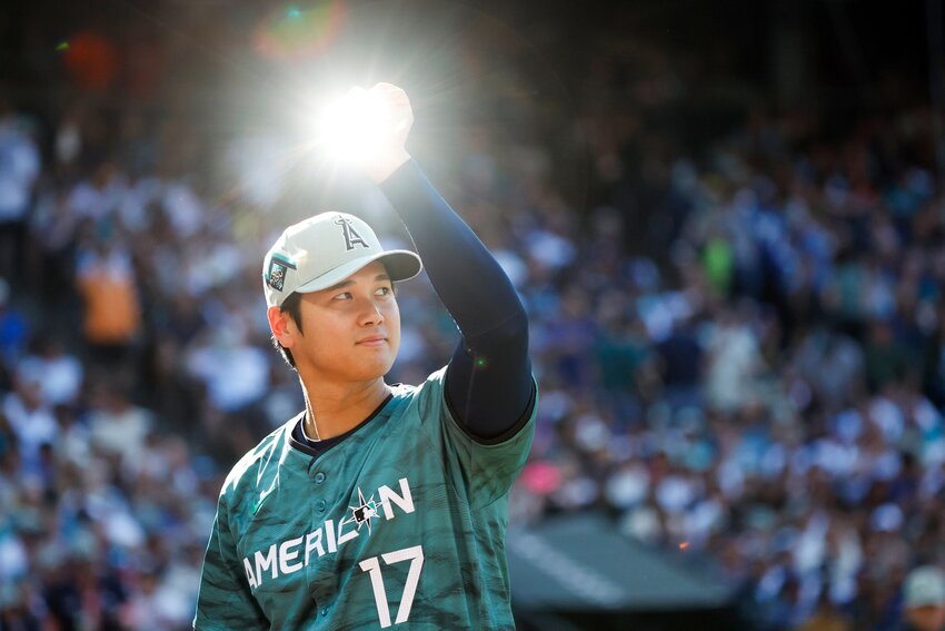 American League pitcher and designated hitter Shohei Ohtani raises a trophy that catches the light during the 2023 MLB All-Star Game July 11, 2023, at T-Mobile Park, in Seattle. Fans in the stands were chanting &ldquo;Come to Seattle.&rdquo; (Dean Rutz/The Seattle Times/TNS)