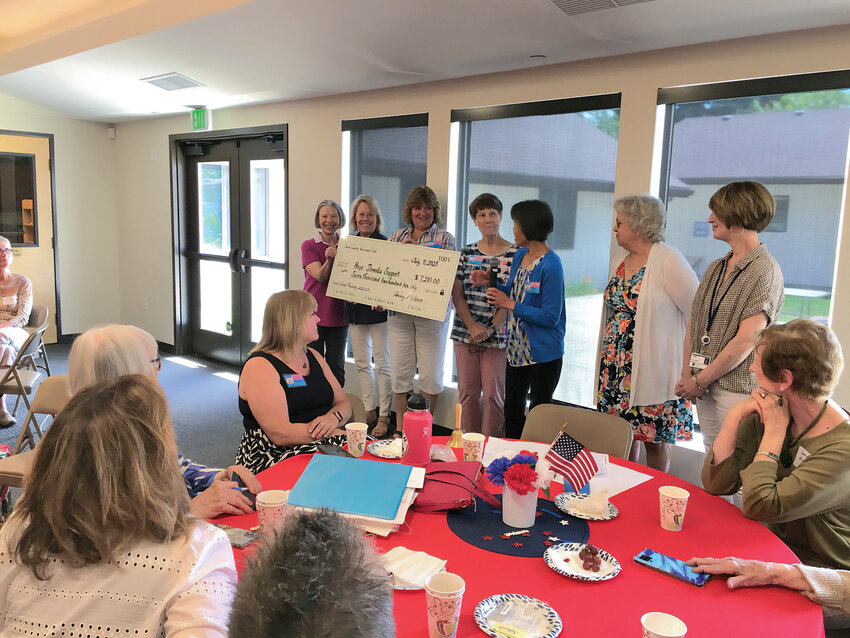 Sandee Swarner, third from right, is pictured receiving a $2,000 gift from IQ Credit Union to Camp Hope of Southwest Washington.