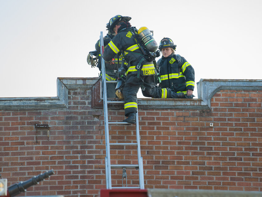 Firefighters climb atop a building while managing an interior fire on North Market Blvd. Tuesday evening, July 25, 2023.