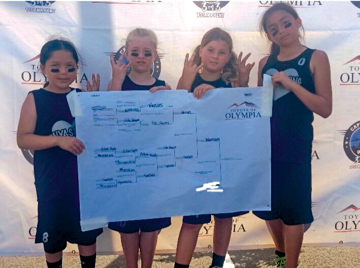 Members of the Nyastrong Warriors Academy pose with the tournament bracket after they won the Capital City 3-on-3 tournament in mid-July.