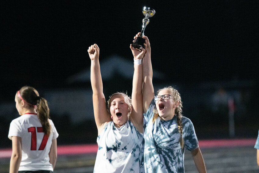 Lena Fragner and Zoey Robertson lift up the trophy after W.F. West's 1-0 win over La Center in the finals of the Battle on the Blacktop, July 30 in Tenino.