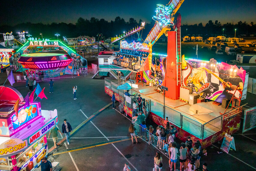 Visitors mingle in lines for rides as the sun sets over the Southwest Washington Fairgrounds in 2022.