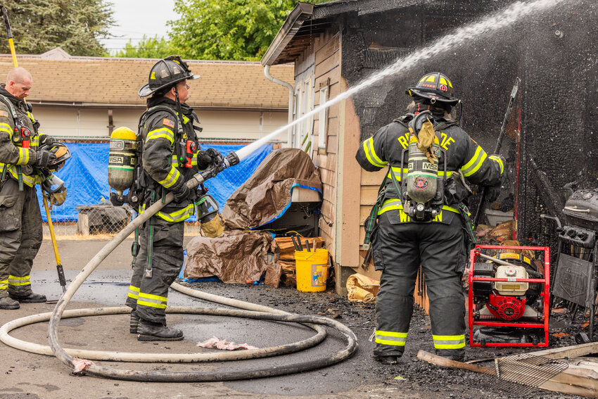 Captain Terry Ternan, with Riverside Fire Authority, uses a hose to spray water while responding to the scene of a residential structure fire in the 1300 block of Southwest Mills Ave. in Chehalis Thursday morning.