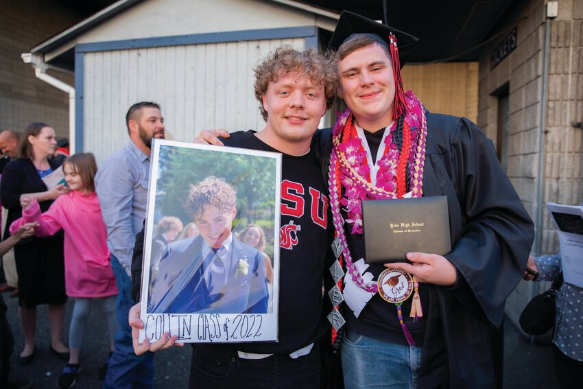 A Yelm High School graduate stands with a photo in memory of Collin McLaren in 2022.