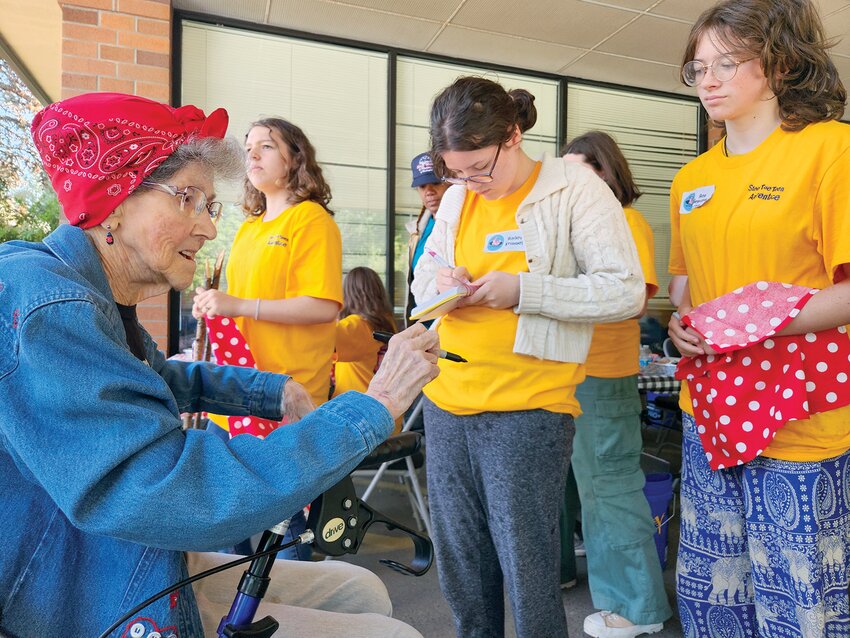Doris Bier, Lewis County&rsquo;s last surviving Rosie the Riveter, signs items for girls at the first-ever Steel Toe Teens camp in this photo provided by Julie McDonald.
