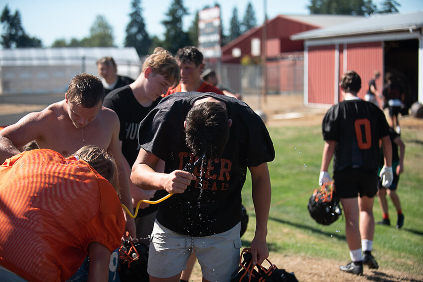 A Napavine player soaks his head with water during a water break at Napavine's first practice on Aug. 16.