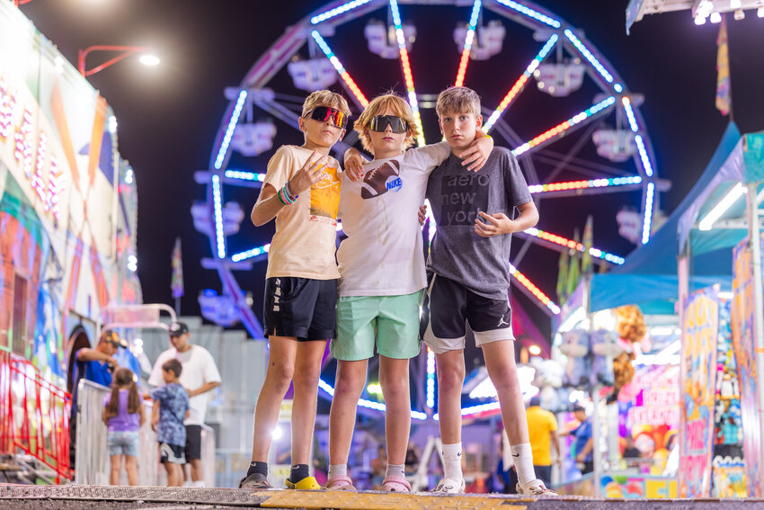 Chehalis visitors from left, Landon Brown, 13, Rocky Placer, 12, and Wyatt Allen, 12, pose for a photo at the Southwest Washington Fairgrounds Wednesday night.