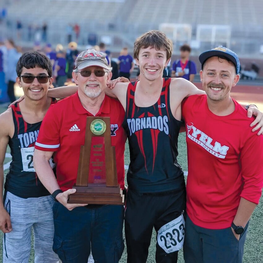 Dan Baker, middle left, poses with athletes Paul Manwiller (left), Zach Walsh, middle right, and coach Alex McIntire, right, at the 3A track and field state championships in May.