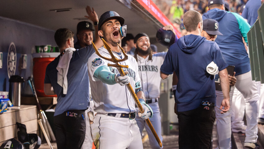 Julio Rodr&iacute;guez celebrates a home run as J. P. Crawford smiles and receives high-fives behind him inside the Mariners dugout at T-Mobile Park in Seattle on Monday, Aug. 28.