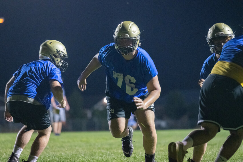 Jackson Knittle works through a gap during a line drill at Adna's midnight practice to open training camp on Wednesday, Aug. 16.