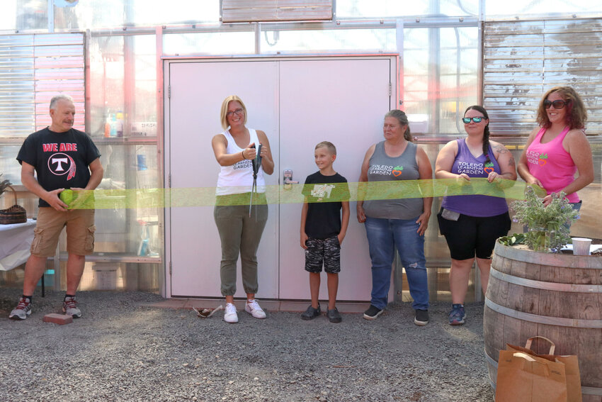 Toledo Learning Garden board members and volunteers prepare to cut the ribbon and formally open the garden&rsquo;s new greenhouse at Toledo Elementary School on Saturday, Aug. 26.
