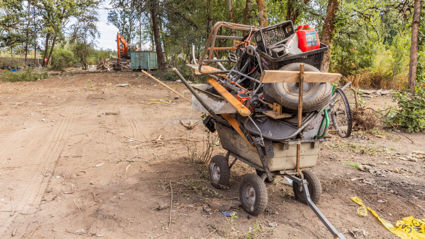 A wagon packed with belongings sits at the end of Eckerson Road in Centralia as structures in a homeless community are demolished by crews from the Washington State Department of Transportation, which owns the land, on Wednesday, Sept. 6.