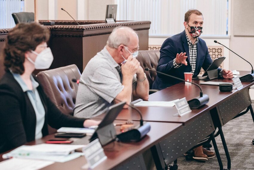 FILE PHOTO: Commissioner Sean Swope asks questions during a Board of Health meeting in December 2021 alongside former commissioner Lee Grose and Commissioner Lindsey Pollock.