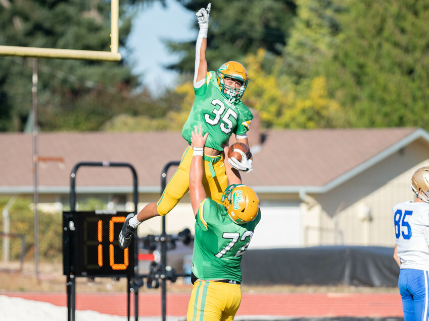 Brady Larson (72) lifts up Kooper Clark (35) after Clark's second touchdown of the game during the first half of Tumwater's 54-0 win over Kelso on Sept. 15.